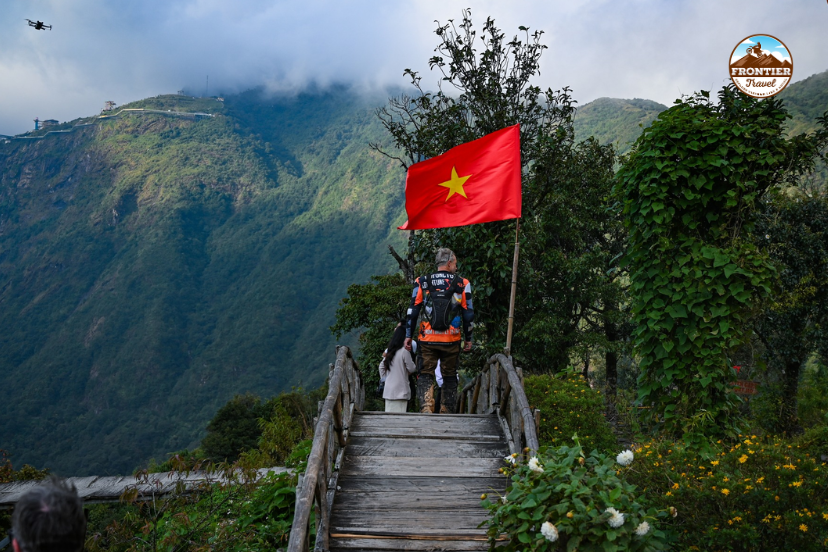 Traveler standing under cloudy mountain skies during a highland journey with Frontier Travel Vietnam.
